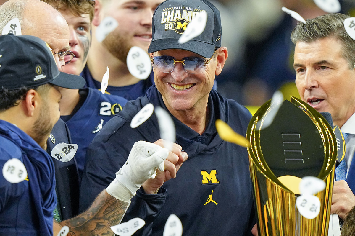 Confetti falls on Jim Harbaugh as he holds the national championship trophy after the title game.